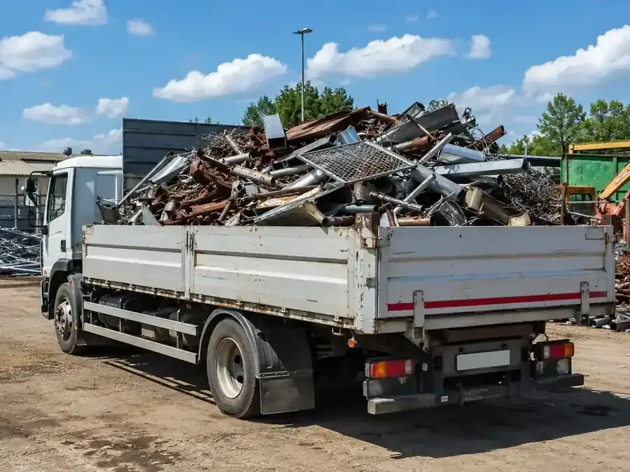 Voll beladener LKW mit Kellerschrott, Metallregalen und Rohren nach einer Kellerräumung