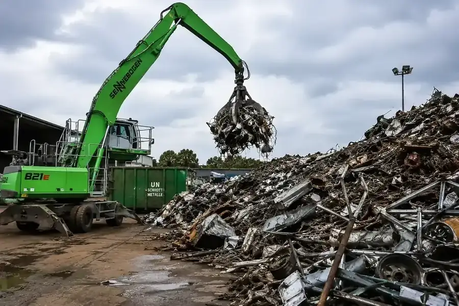 Schrottplatz mit Bagger und Metallberg – Verwertung von Altmetall aus Kellerentkernungen